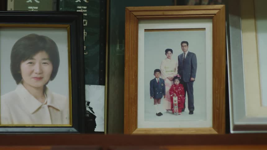 There are pictures on a shelf inside of someones house