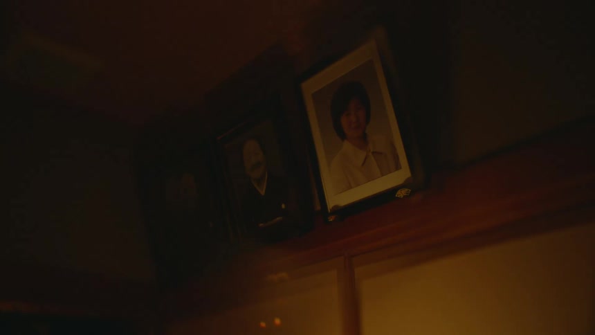 A couple of portraits hanging from the wall near the ceiling on a japanese home