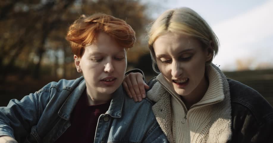 A young couple is sitting outside in the middle of the day time