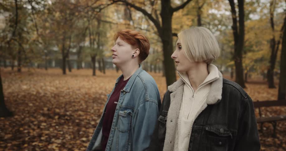 A young couple is walking outside and holding hands