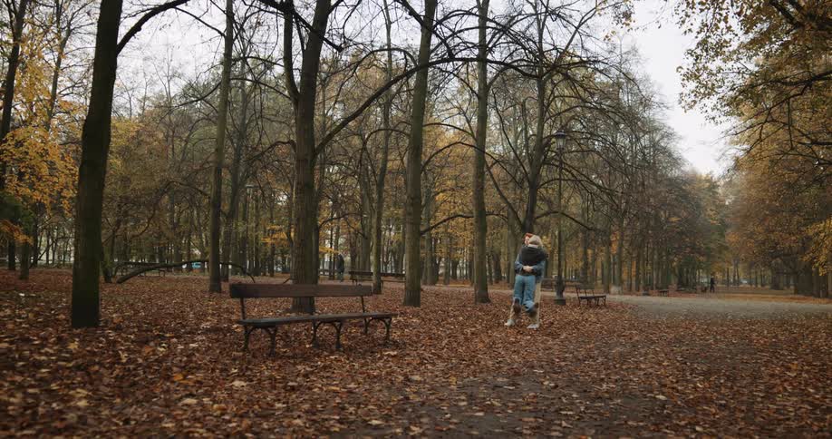Young couple hug and kiss on the park at fall