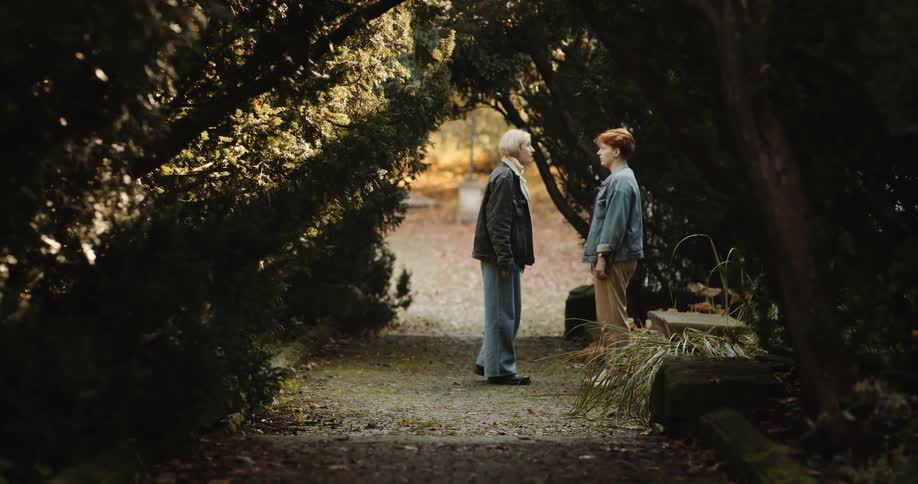 Two women walking along path argue and the blonde pushes the redhead before walking away angrily