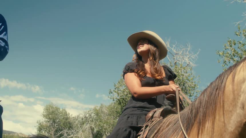 Man and woman are riding horses together outdoors
