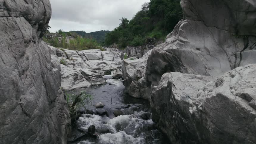 The view is of a river by some rocks in the middle of the day