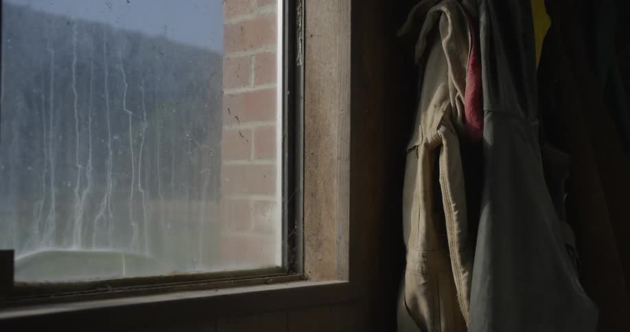 Coats and jackets hung on clothes hanger near the window