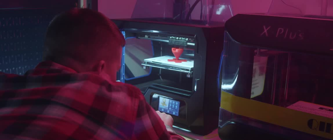 A young white man is using some machine inside of his home