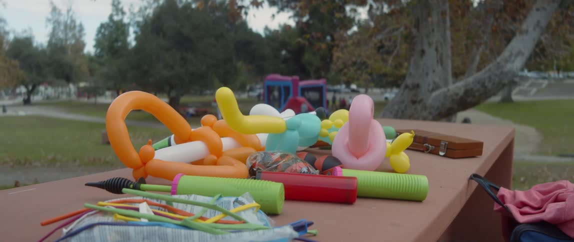 Children play in a bounce house set up for a party in the park