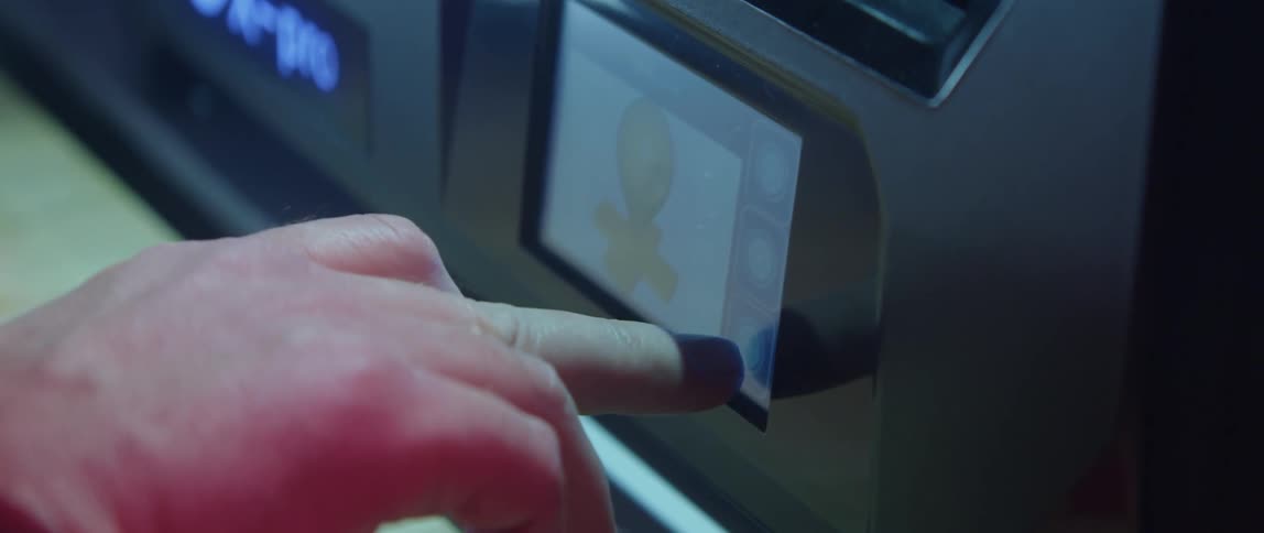 Someone is using their fingers to push the electronic touch screen on a machine