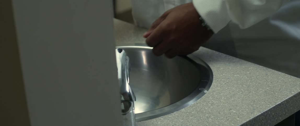 A man washes his hands in the sink