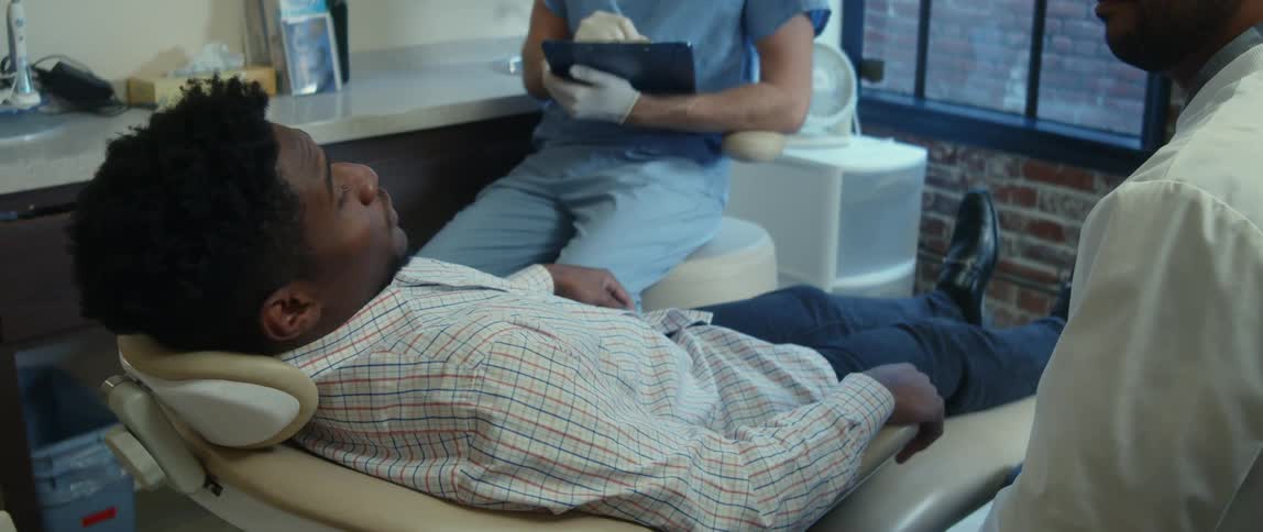 A dentist is talking to a patient