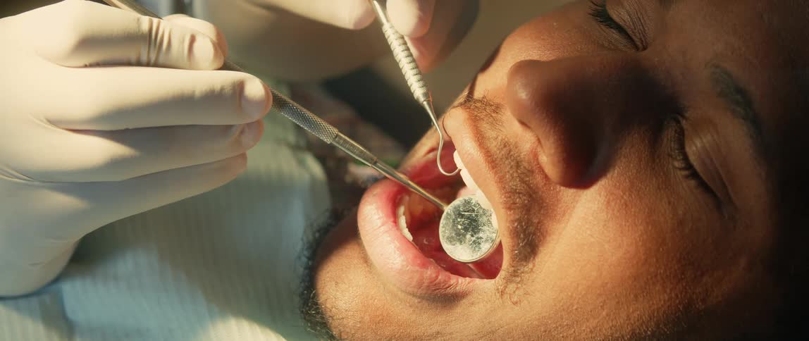 Mirrored tool creates glare as dentist examines patients teeth