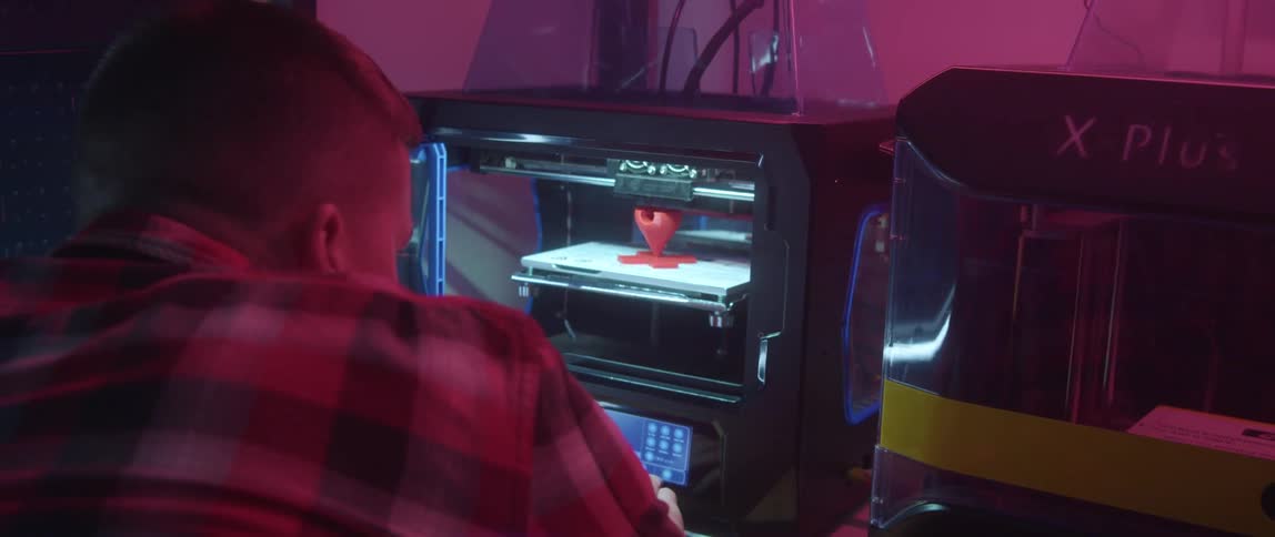 A man using a 3d printer in a room