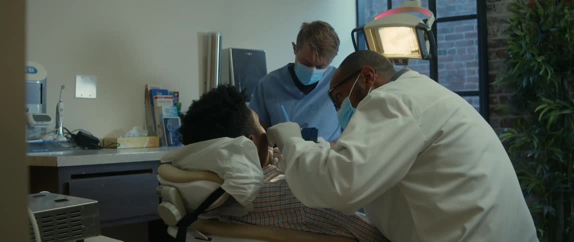 Two dentists working on a persons teeth