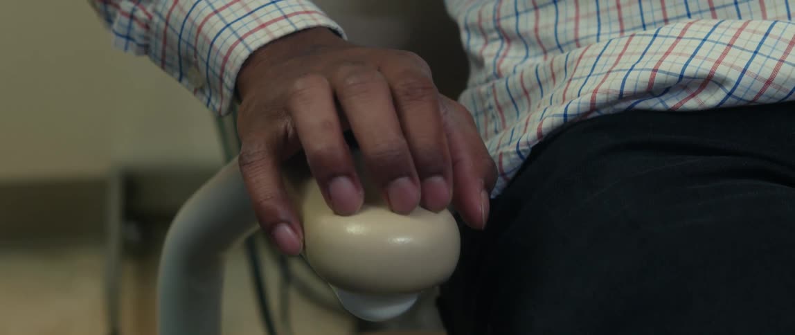 A man nervously taps his fingers on the arm of a chair