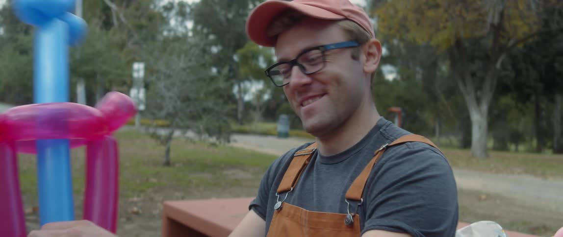 A young white man is outdoors and setting up a party