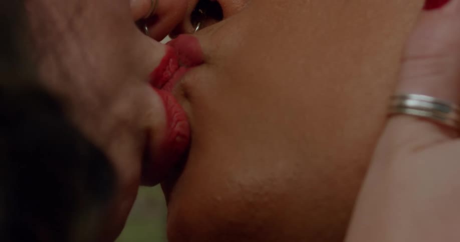 Close up of the red lips of a couple women kissing