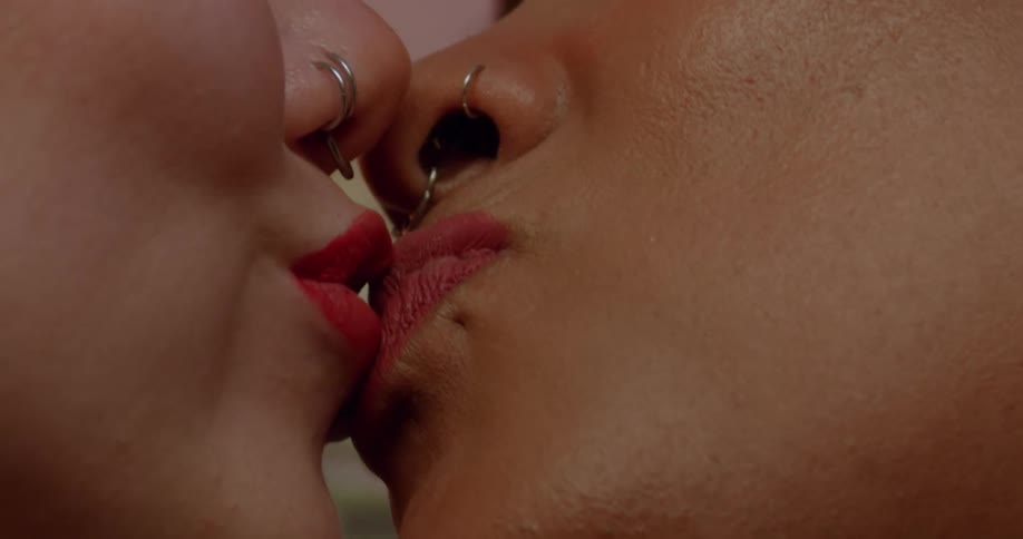 Women wearing lipstick and nose piercing make out and smile happily