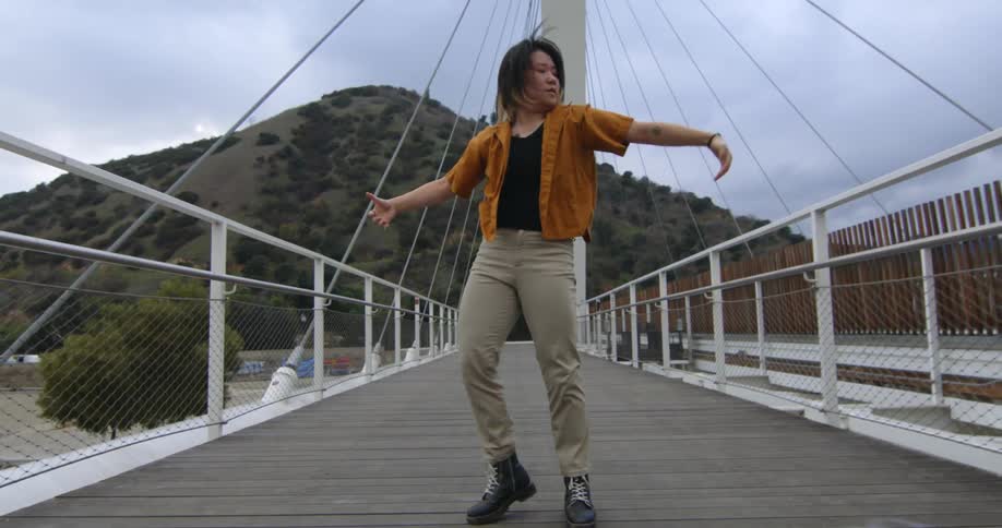 A person dancing their way down a bridge