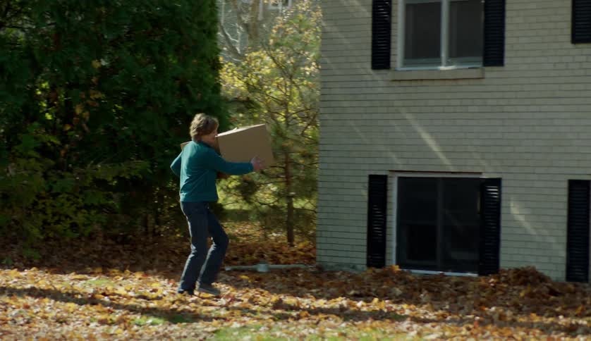 Family moving cardboard boxes inside a house at fall