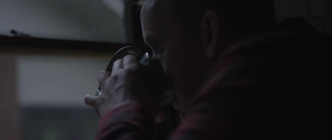 A man drinks from his mug