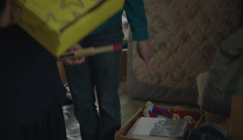 A woman and boy pack items in the boxes