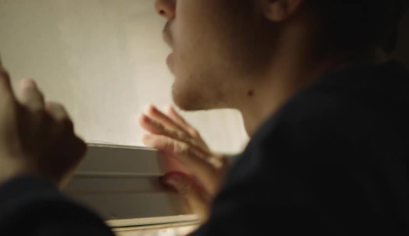 A teenager opens the window