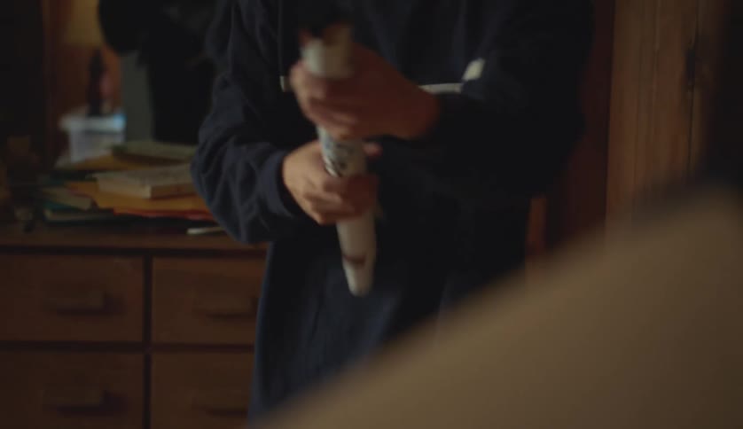 Man rolls up poster and hands it to woman who looks through the tube