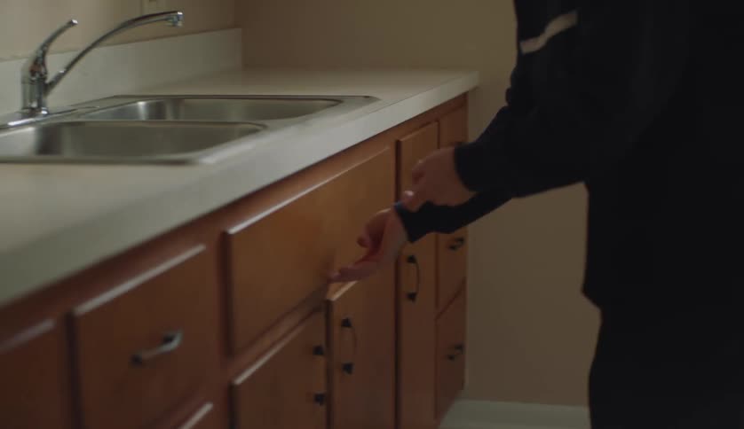 A man is going through the kitchen in the middle of the day