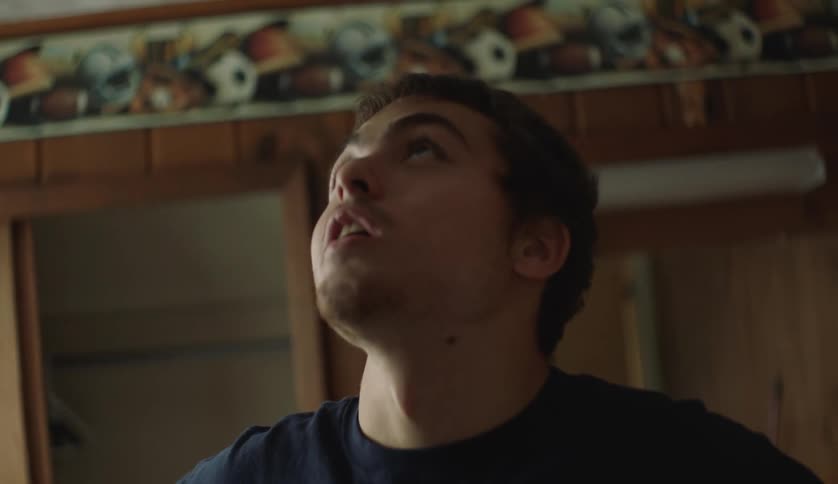 Young man standing on a room at home looking up at the ceiling