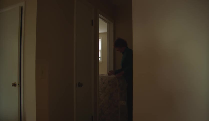 Mother and son are carrying a mattress inside of there house