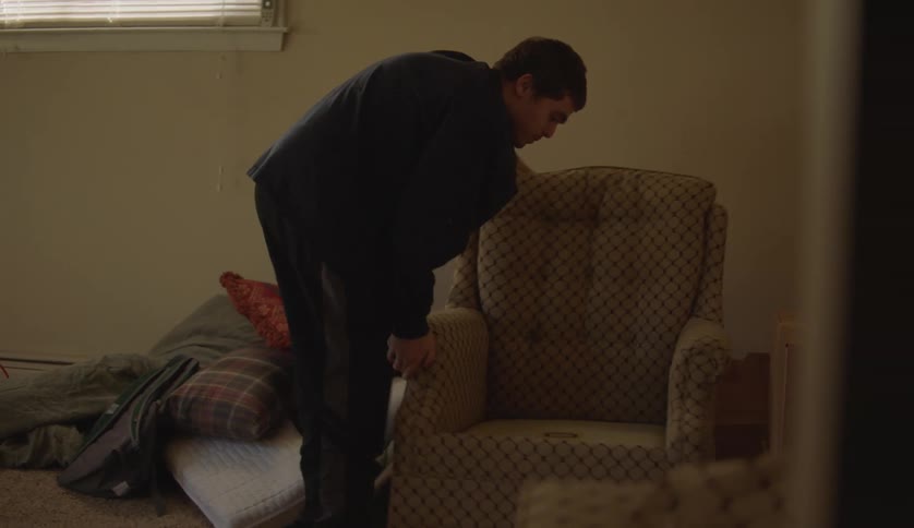 Young man with special needs assembles a chair in the living room