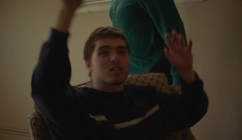 Teenager with special needs sitting on a chair on the living room throwing a ball
