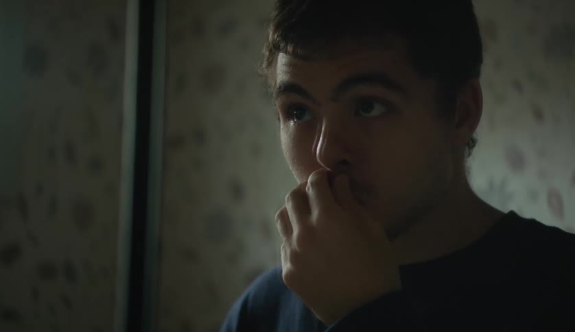 Man touching his upper lip staring up in room