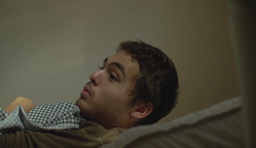 Young man with special needs laying in bed in his bedroom