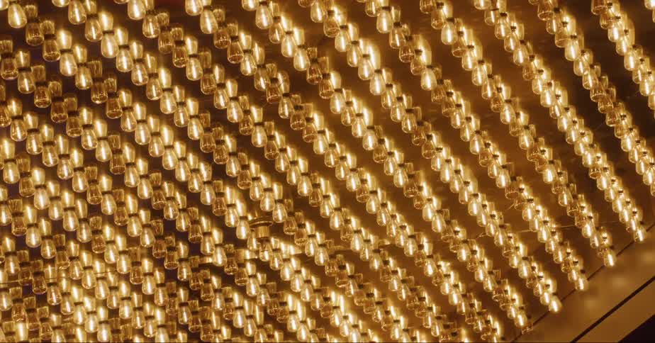 Hundreds of light bulbs shimmer on the ceiling of a building