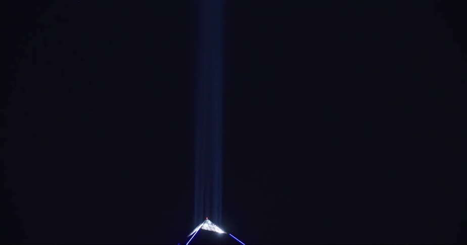A bright flare shines off the top of a high rise building