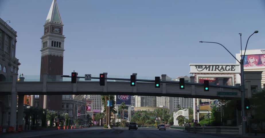 Vehicles drive through an intersection and under a bridge headed toward downtown