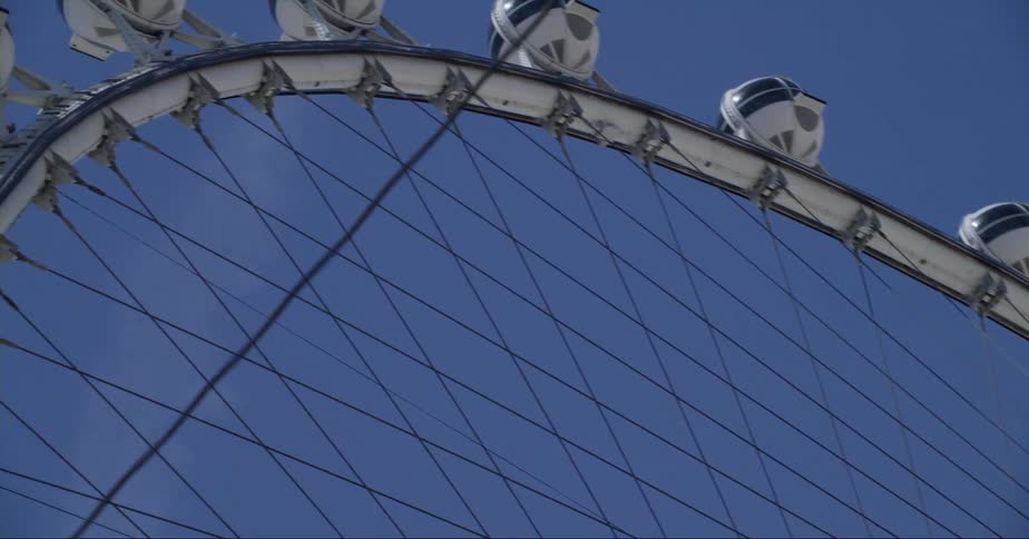 A ferris wheel is shown close up against a blue sky