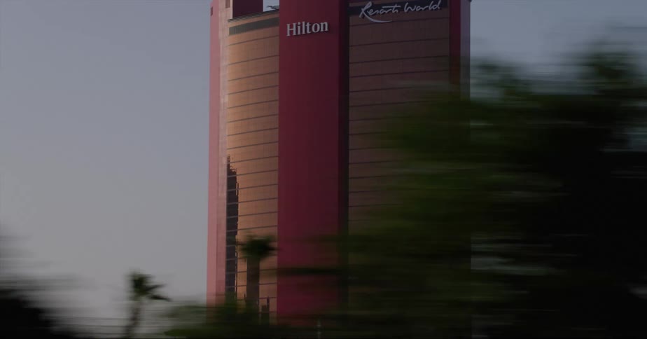An airplane flying past a high rise hotel in a city