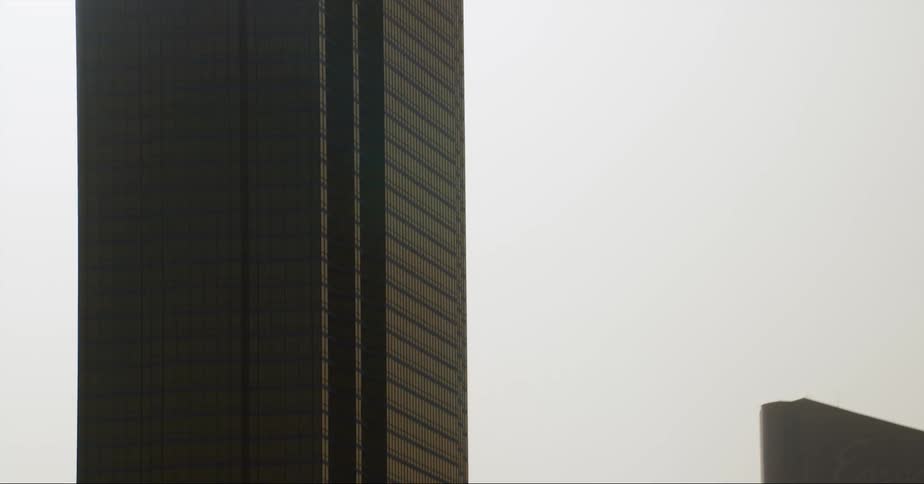 Office buildings are silhouetted against the shining sun in the city