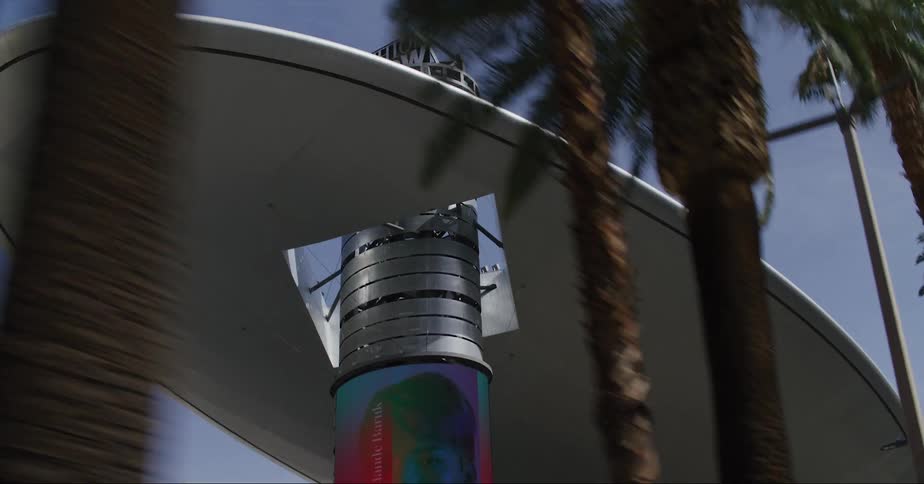A large structure with advertisements on screens in a city