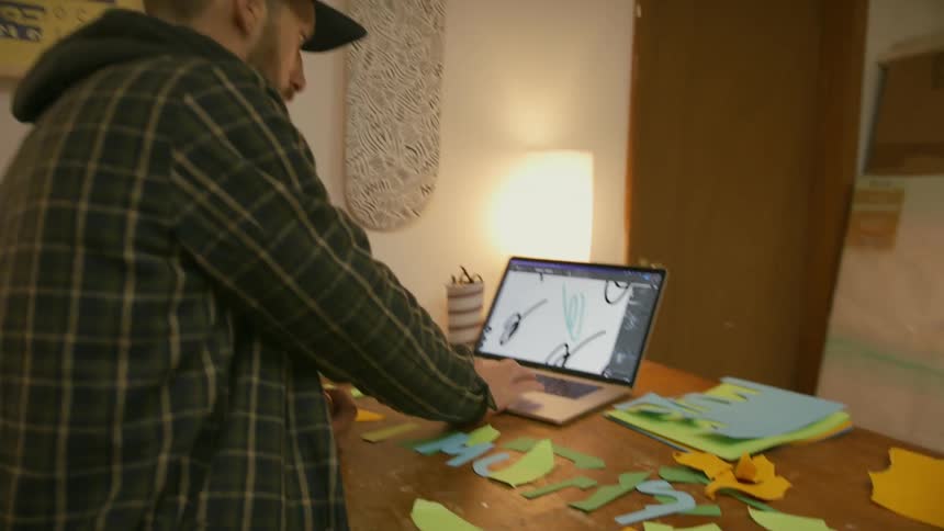 A man is designing something on his laptop