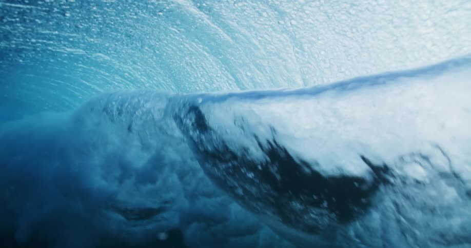 A wave breaks in the ocean as seen from underwater