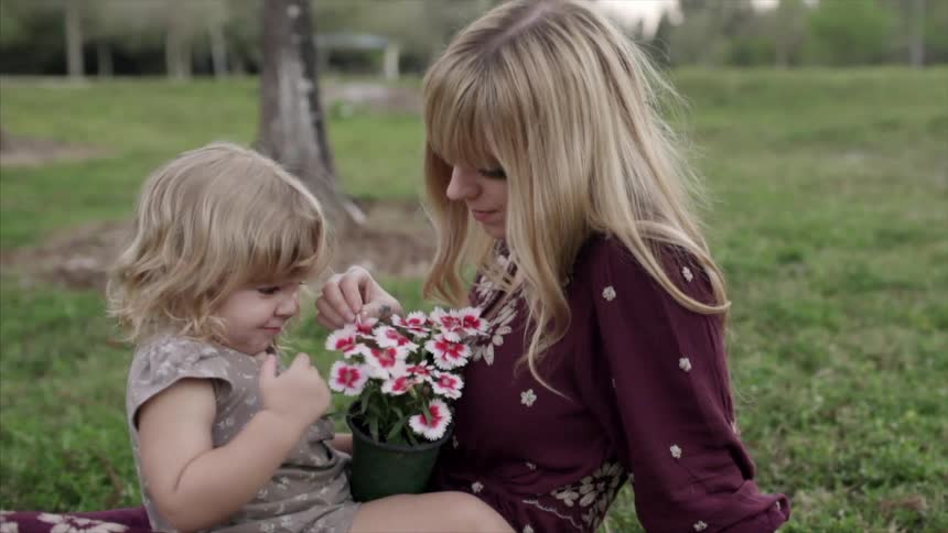 A woman and child play with flowers