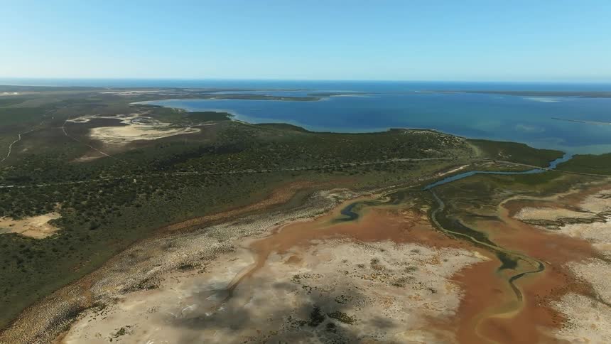 Aerial view of land next to the sea