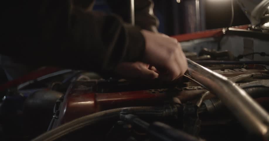 Car mechanics work on car engine together