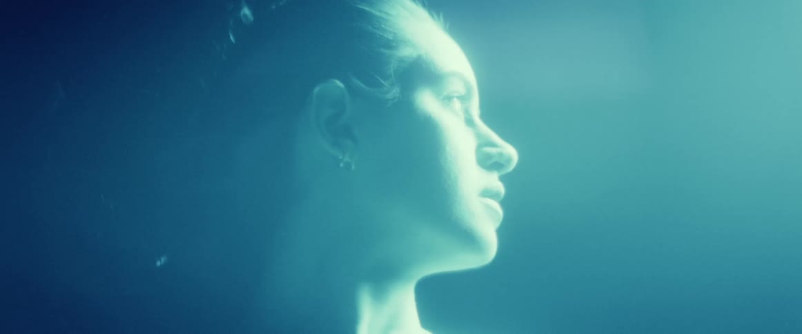 A women looking around while lights are flashing across her face