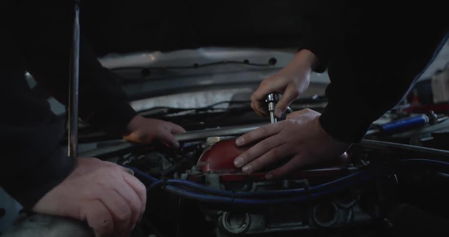 Two men are fixing the inside of a carhood