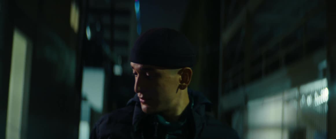 Worried man walking on a dark alley in the city at night