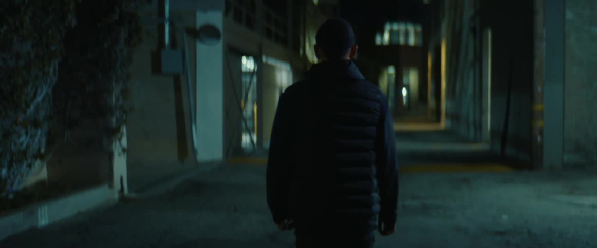 Man walking on a deserted alley in the city at night